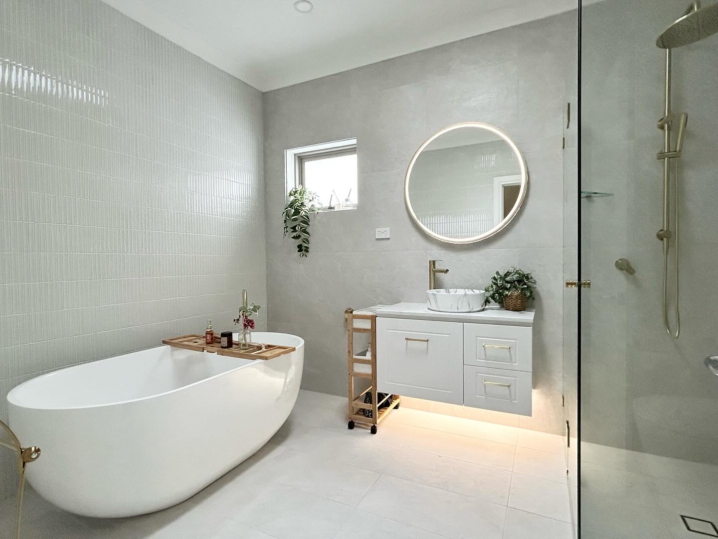 Bathroom with a freestanding bath and round vanity mirror